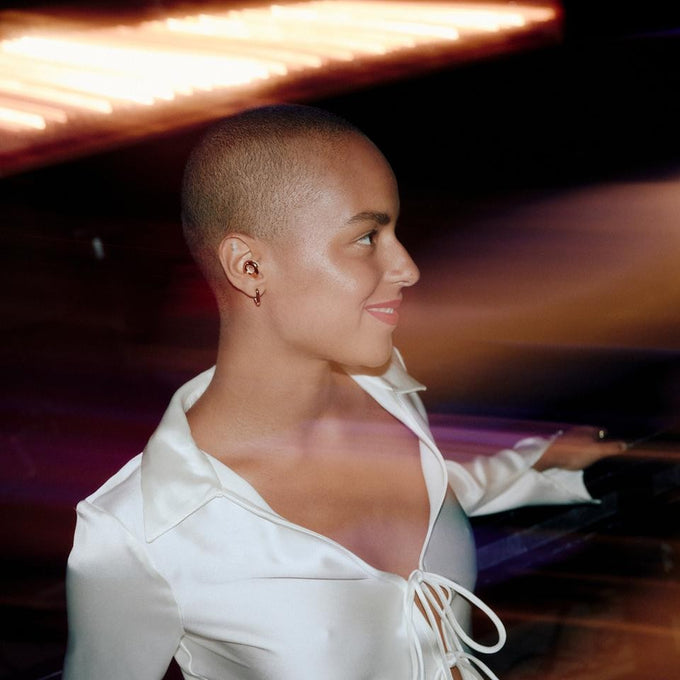 Woman in a white shirt with blurred lights in the background wearing Loop Switch 2 earplugs