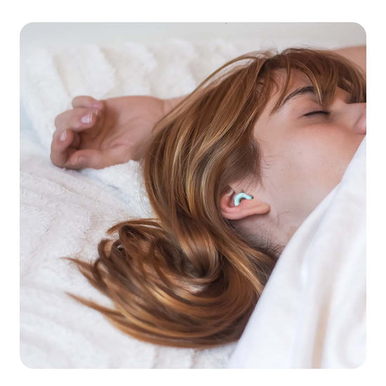 Image of a woman sleeping wearing Loop earplugs.