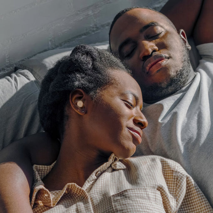 Couple sleeping with Loop Dream earplugs in ears