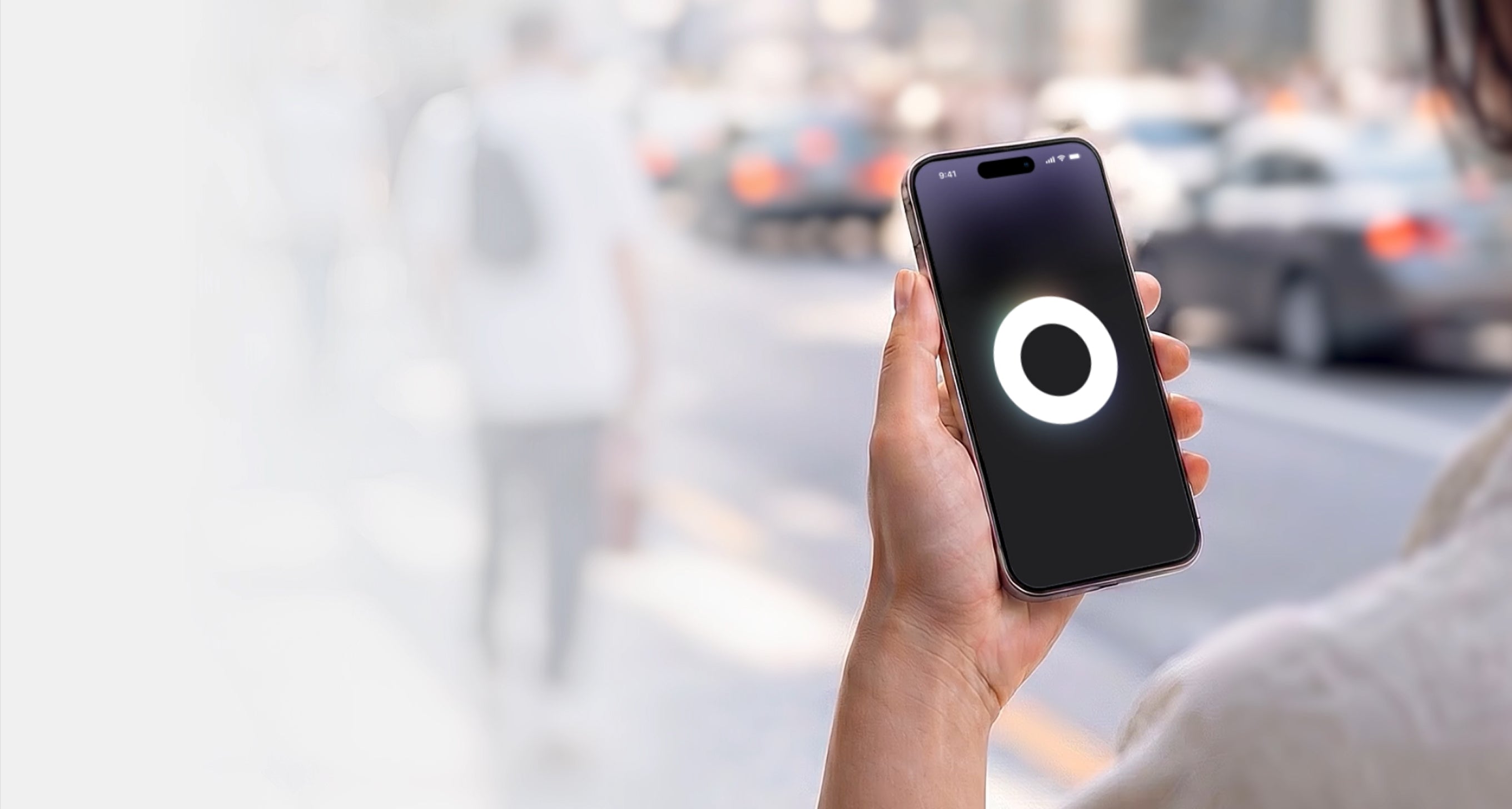 Hand holding a smartphone with the Loop Sphere app icon on a blurred city street background
